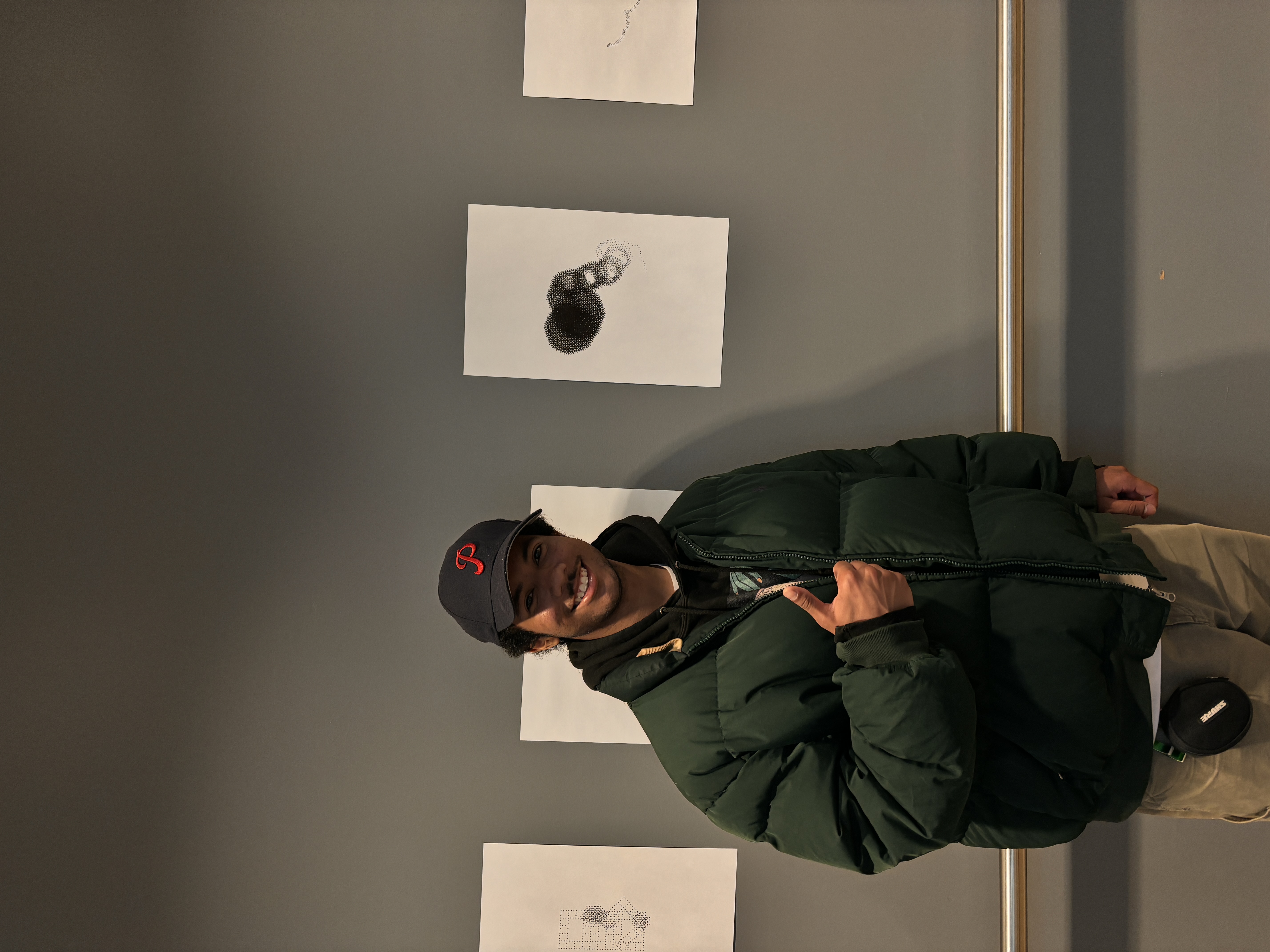 A man standing next to a generative art flower gives a thumbs up at the camera.